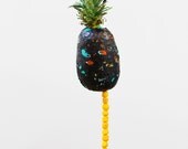 heat sealed WHOLE FOODS bags around non genetically modified PINEAPPLE with endless Cheeto bites dangling in the Wind (Poetic Justice)