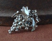 A Bacchanalian Amulet, a cluster of grapes chased and repoussed in sterling silver