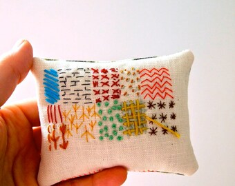 Hand embroidered display pillow with lavender abstract