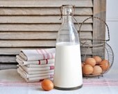 large antique french milk bottle with rustic metal handle and clasp
