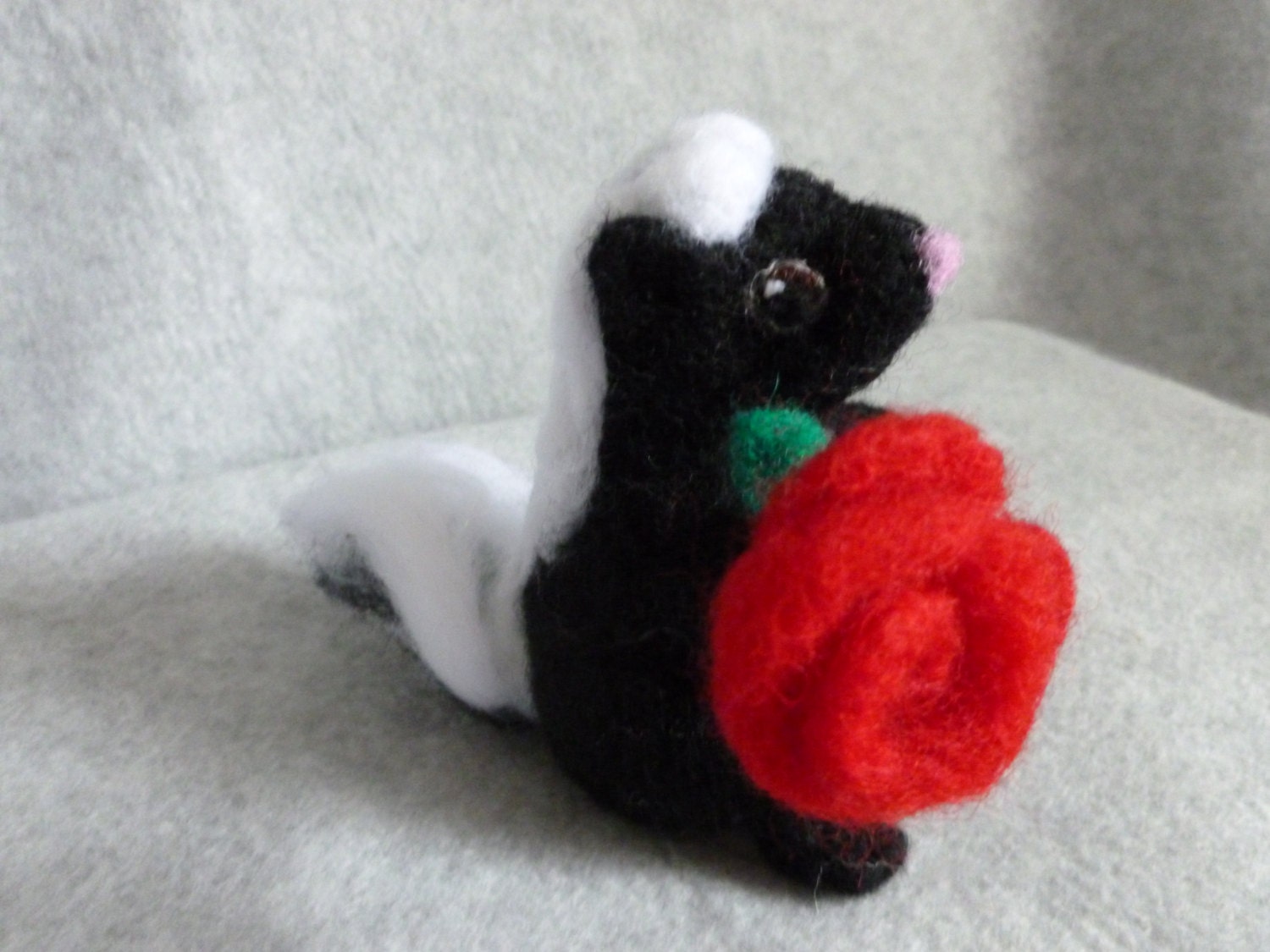 Skunk needle felted animal soft sculpture holding red rose