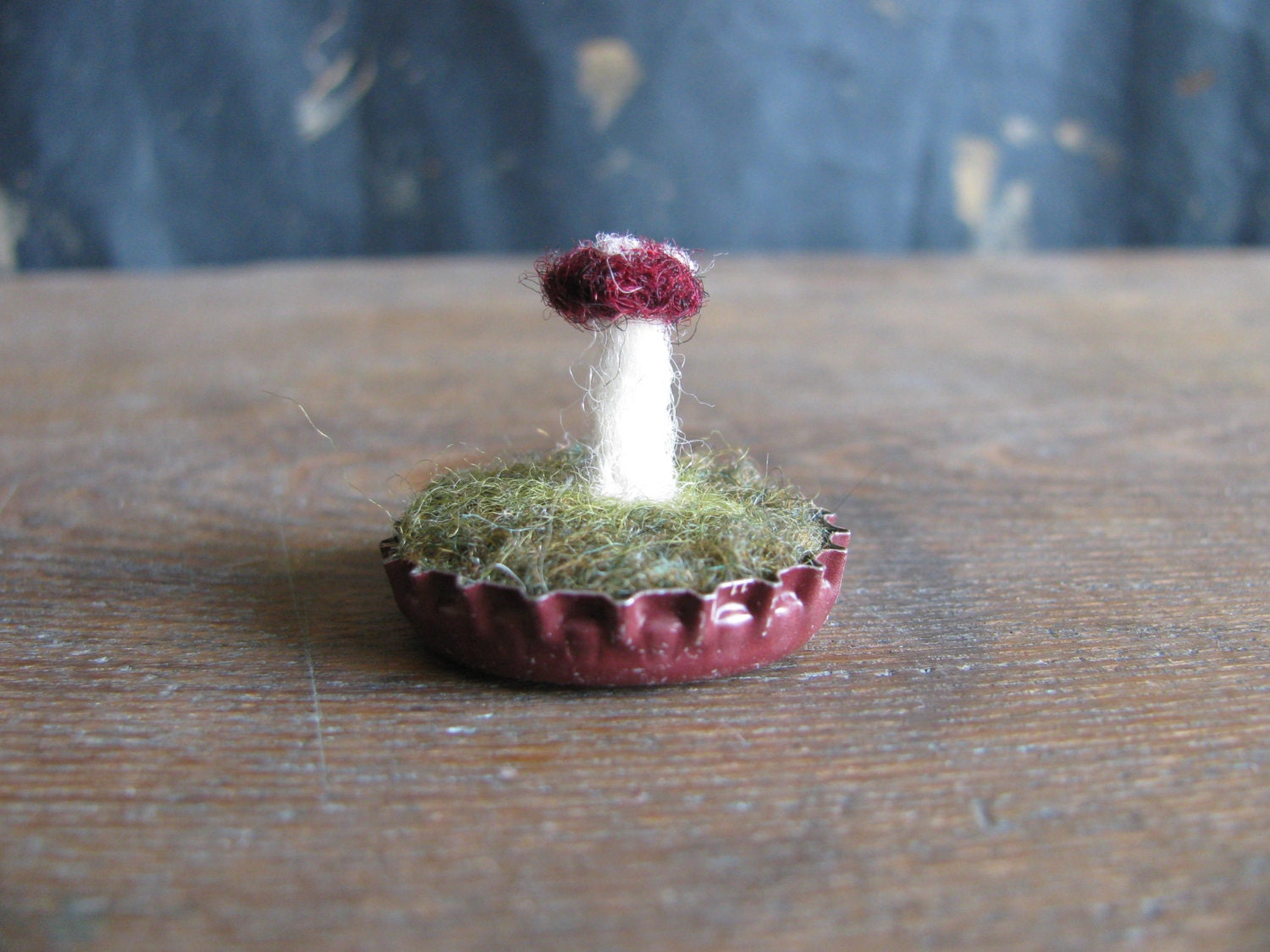 Felted black cherry red amanita mushroom in a dark red bottlecap