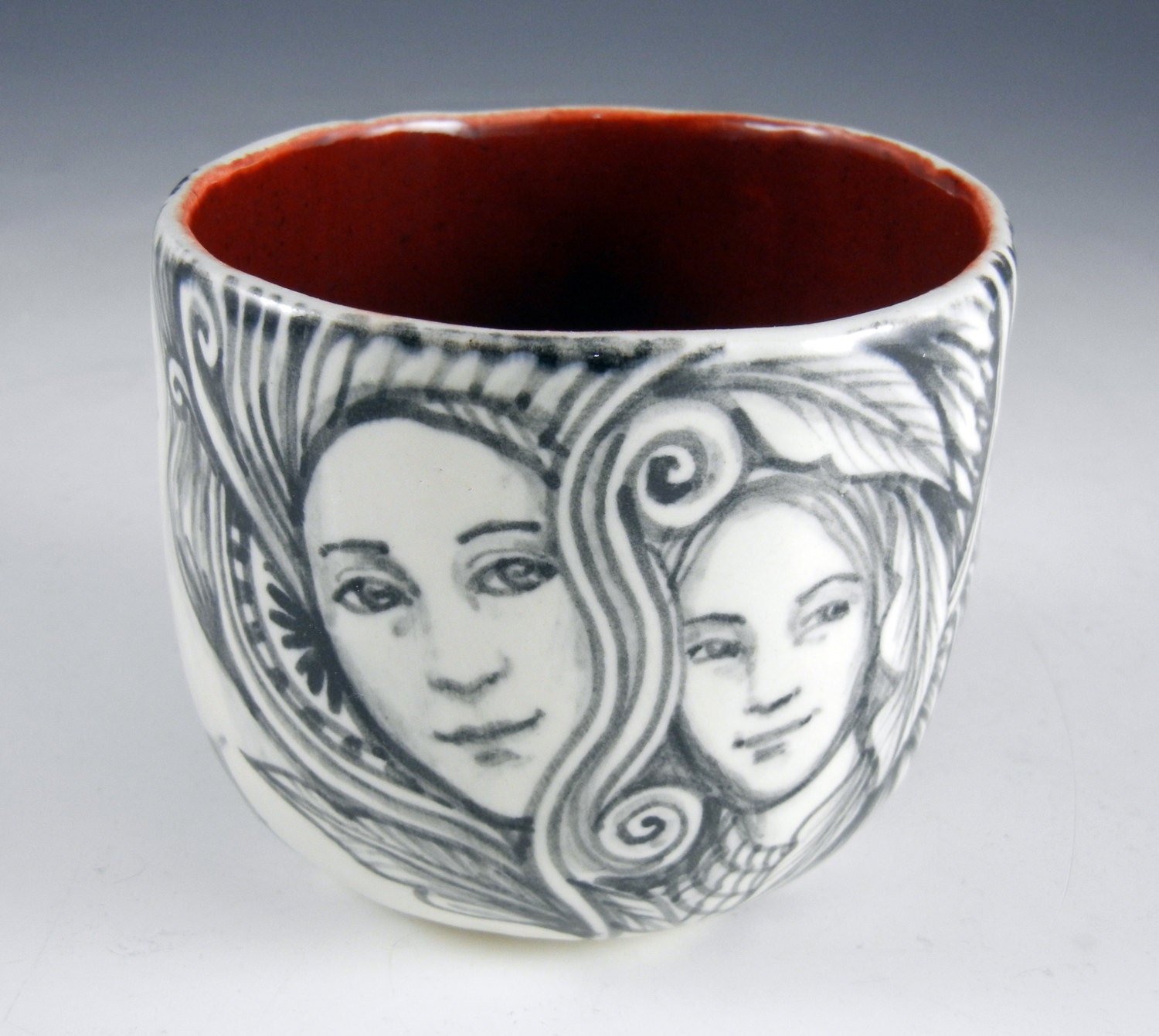 Black and white porcelain story cup with faces,bird and eye