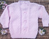 Little Girl's pale pink patterned handknit sweater.