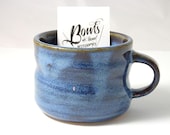 Small mug glazed in textured blue glaze breaking brown