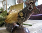 Wood bird with chippy paint embellised with found objects mounted on old bronze baby shoe