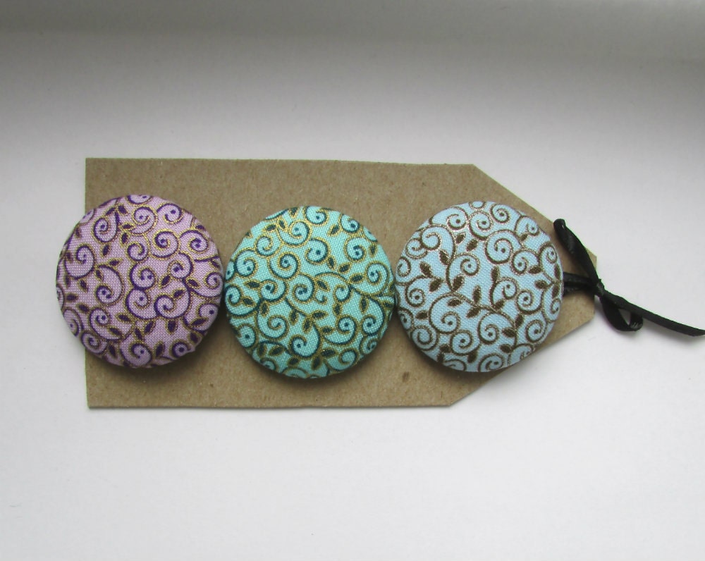 Big buttons, 3 1 1/2 in covered buttons with leaves and swirly stems, gold and silver on teal, blue and lavender