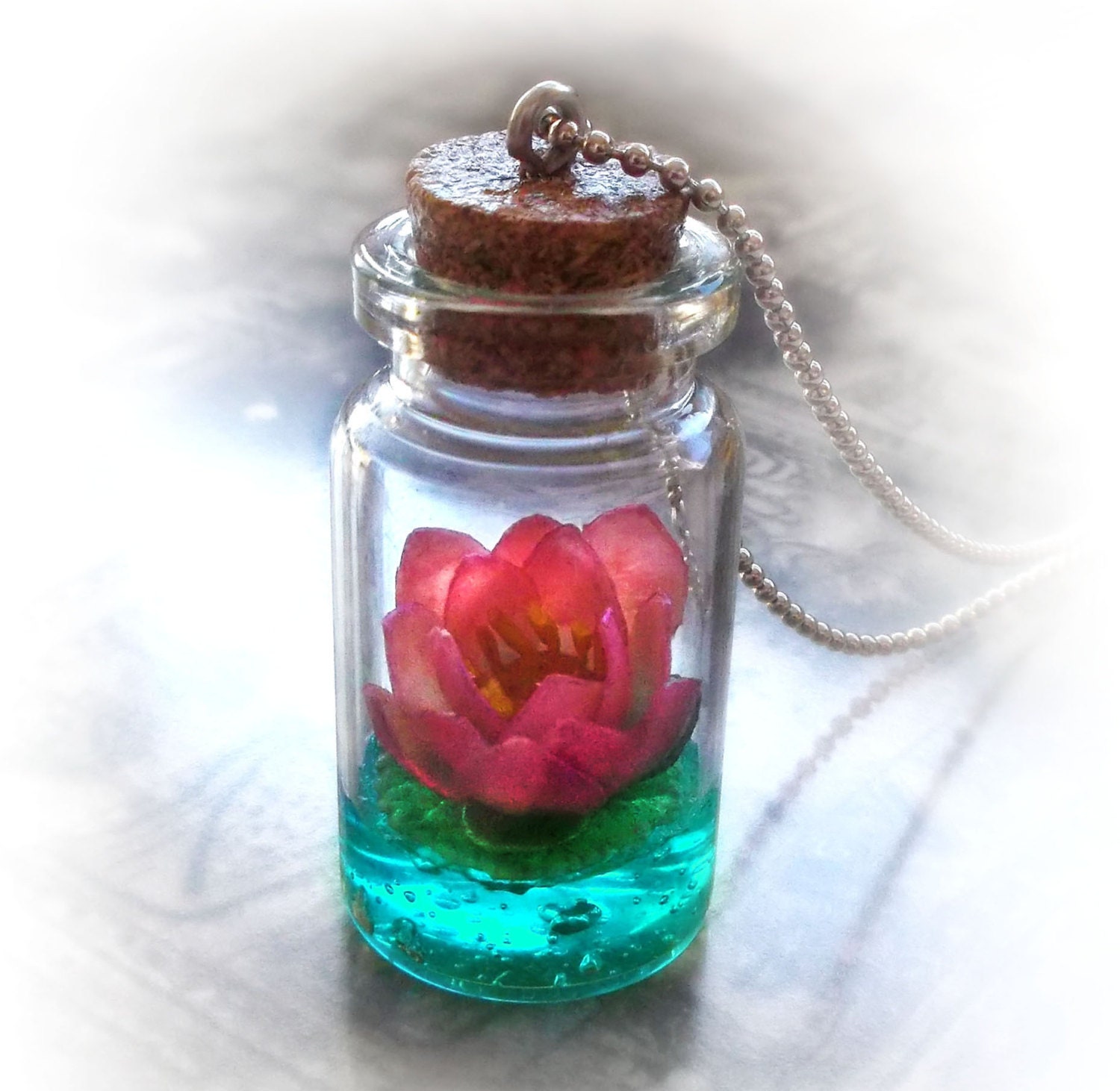 Lotus flower on a magic lake bottle necklace, vial pendant, water lily, pink and vivid blue