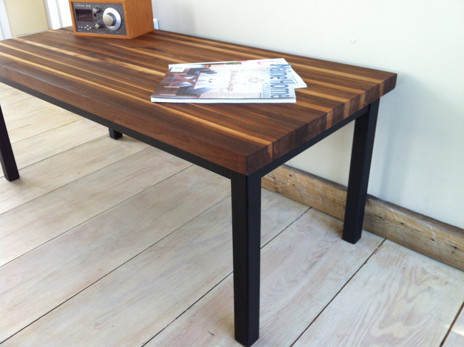 Modern industrial coffee table featuring walnut top and steel base, 18" x 40".