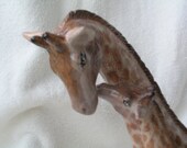 a porcelian giraffe mom and baby done in oils