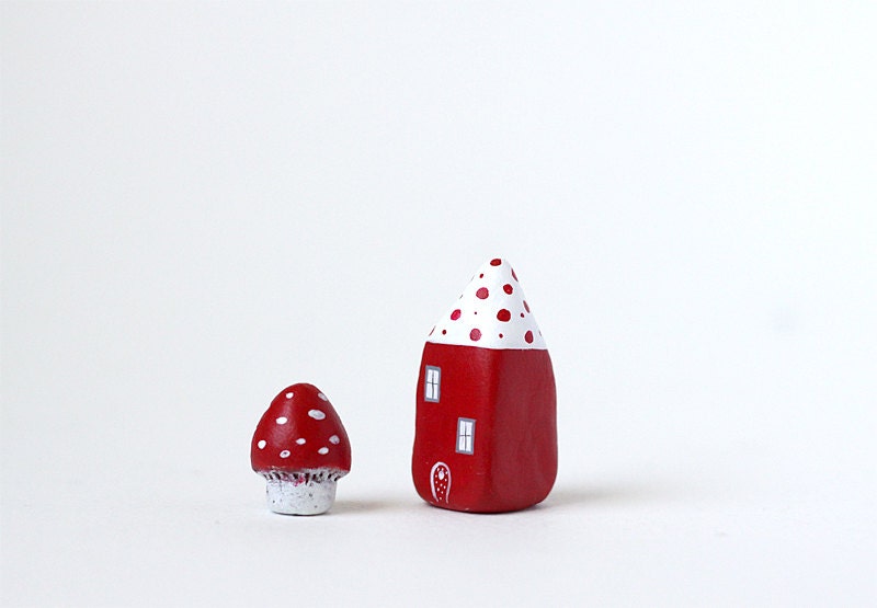 Little red clay house with white roof and red polka dots and a tiny toadstool mushroom