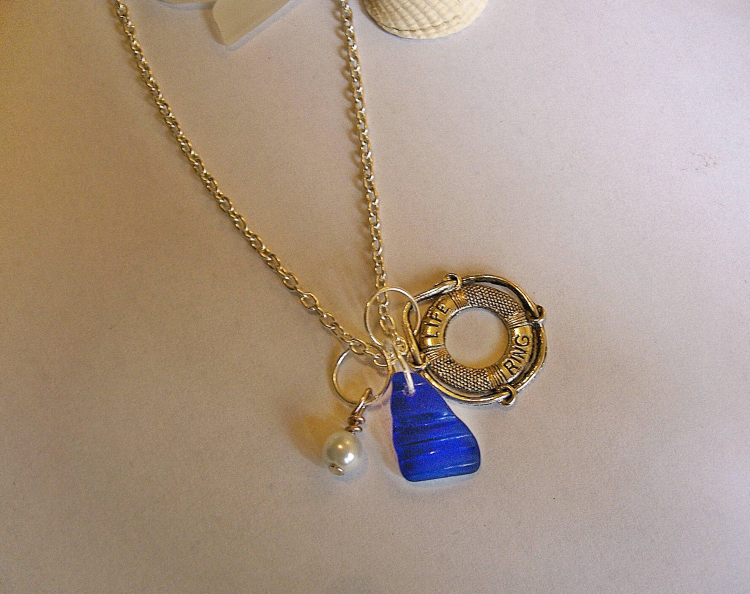 Blue sea glass necklace with lifebelt charm. Seaglass necklace.
