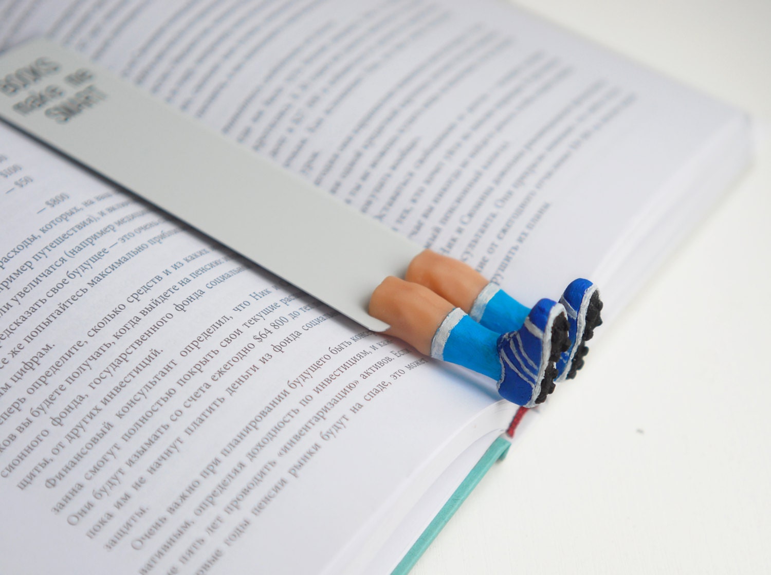Football player legs in the book. Blue sneakers and sporty blue socks. Funny sport. For him, dad, dude, man, all. Unusual art bookmark.