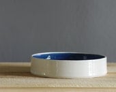 white low bowl with navy blue interior. porcelain plate .  modern handmade minimalist pottery