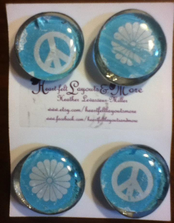 set of four glass magnets with blue and white peace signs, and flowers.