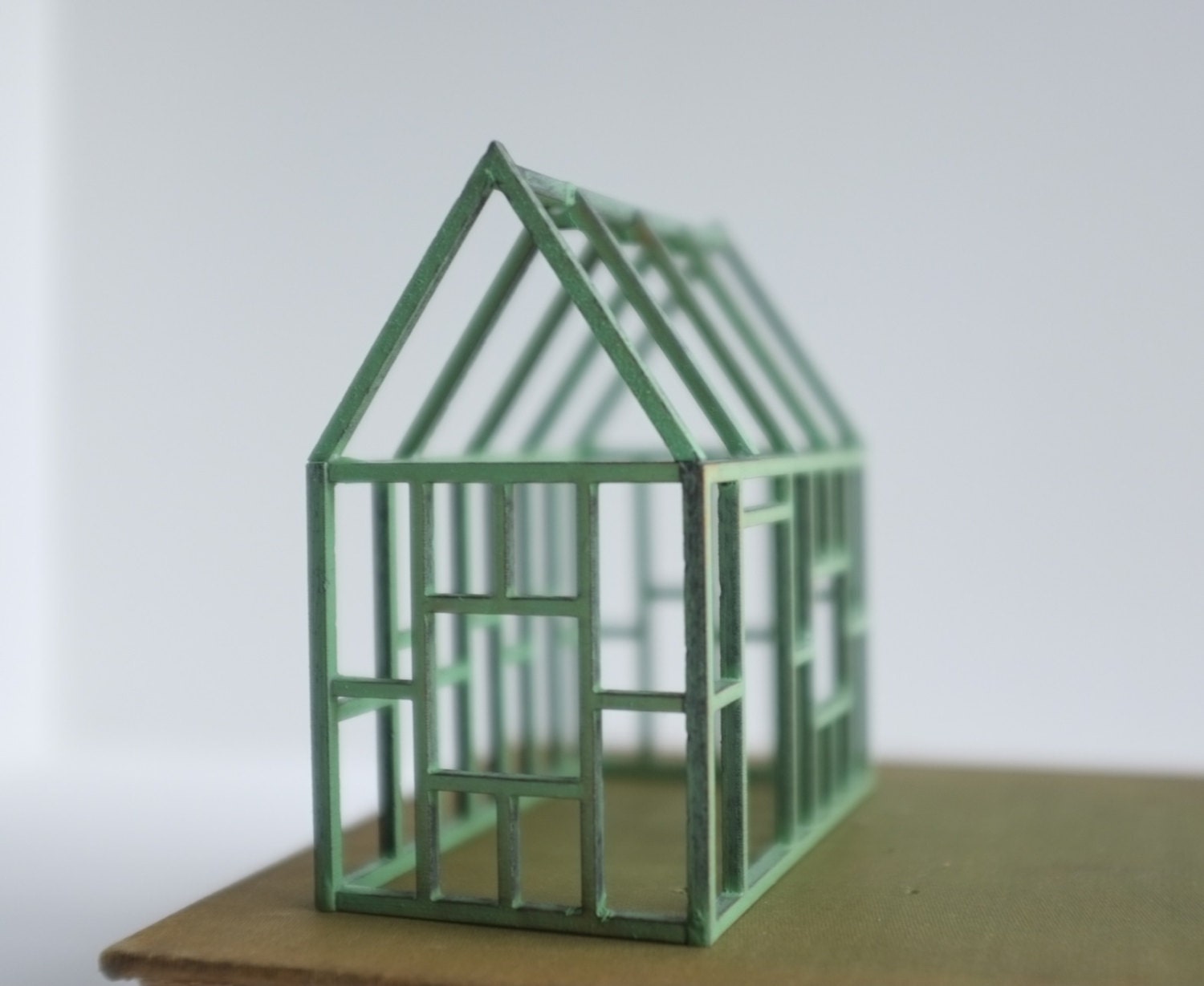 Small verdigris geometric framework house in birch