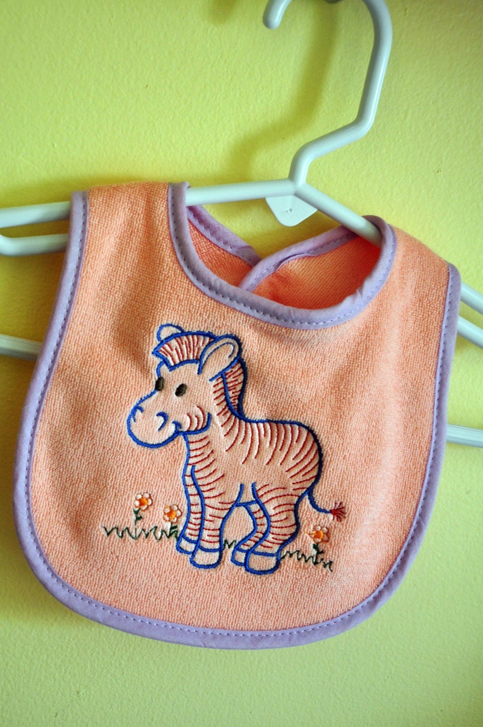 Newborn Size. Apricot and Lavender Embroidered Terry Cloth Baby Bib. Horse and Small Flowers