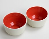 two short and sweet tea cups, fiery red inside, pale gray on the outside, inscribed with love