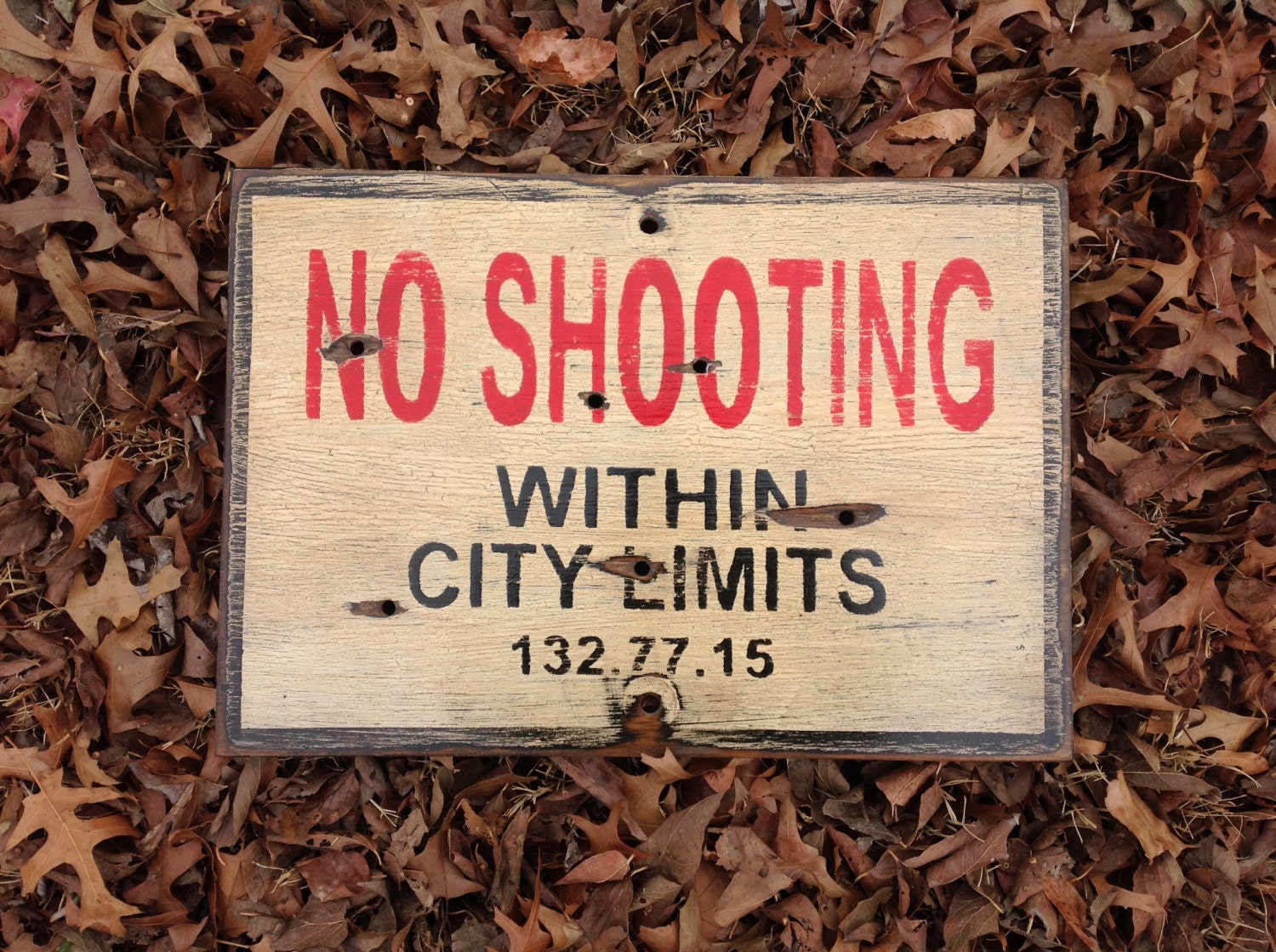 Wooden sign No shooting within city limits sign made from reclaimed plywood