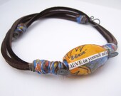 Leather and fiber beaded art choker with decoupaged art beads and whimsical steel spirals. A brightly crafted adornment with pizazz.