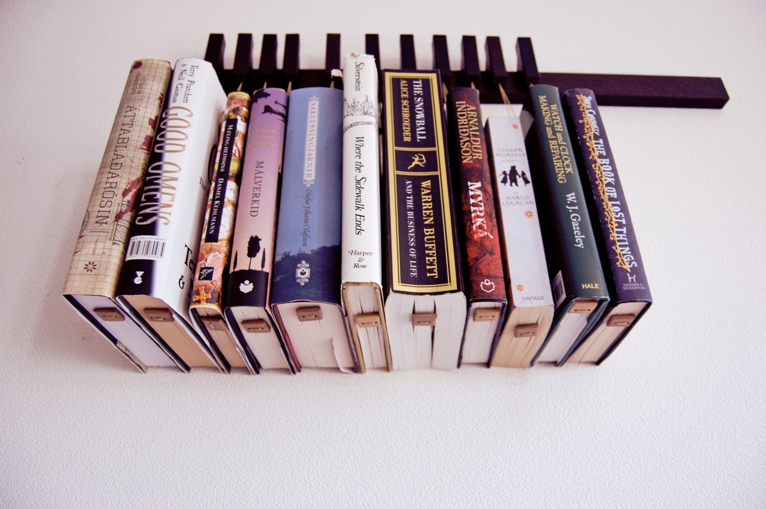Custom made wooden book rack / bookshelf in Wenge. Pins also work as bookmarks. Bookcase