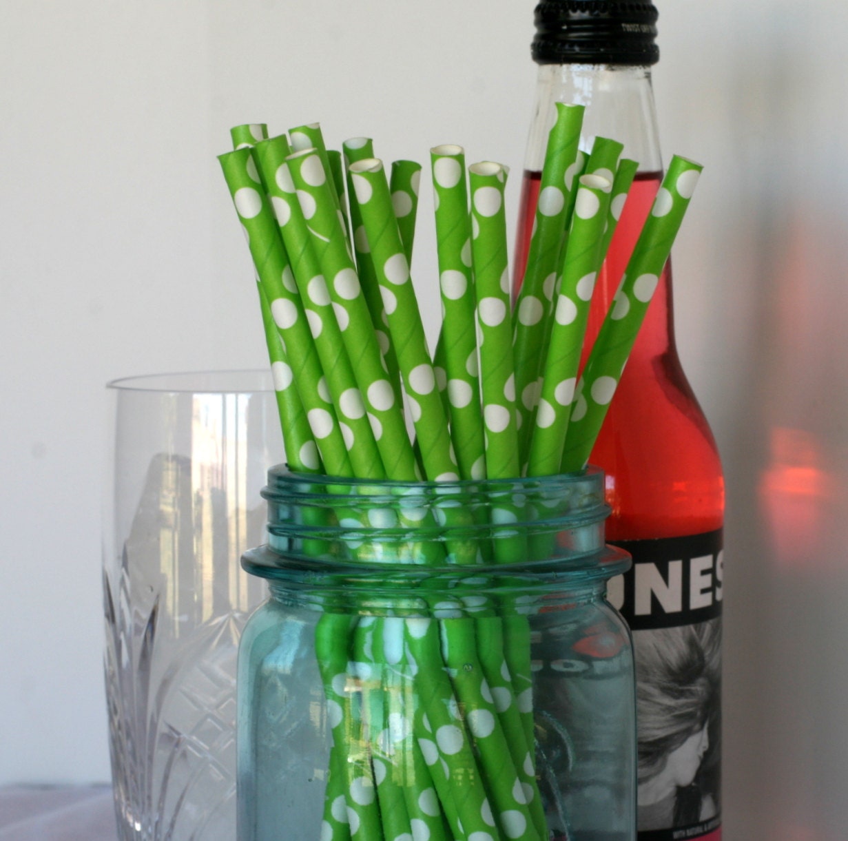 Paper drinking straws in a bright green with white polka dots