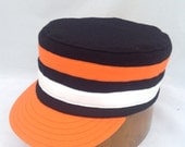 Black wool flannel Box cap with orange and white color bands and visor. Supple leather sweatband, fitted in any size.