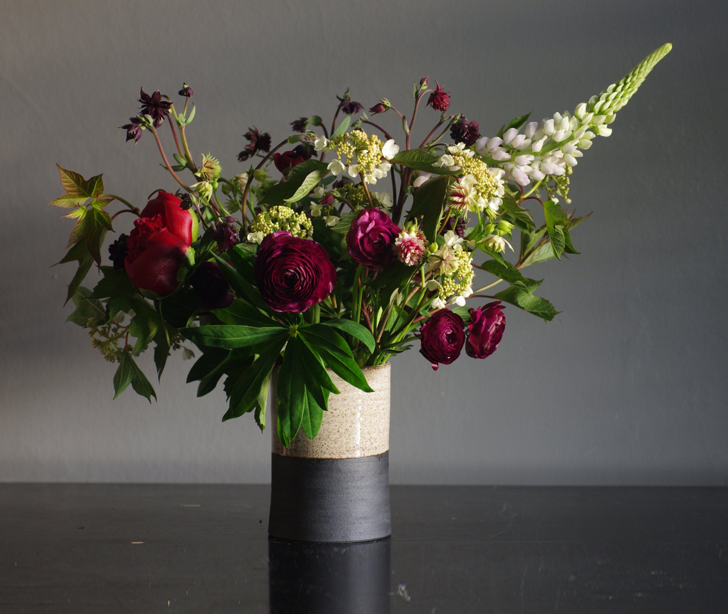 tall straight vase. black stoneware with white glaze. flower vase