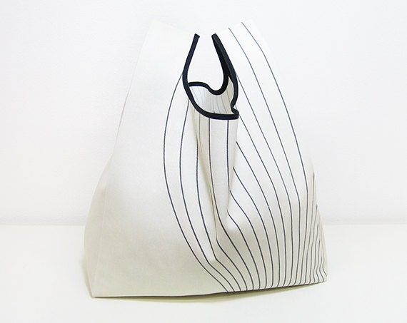 Reusable Shopping Bag, folded into a triangle, blue and white cotton, edged in black ribbon.