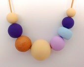 Multi toned almond, mauve, royal purple, rose gold and powder blue handmade polymer clay beaded necklace on leather.