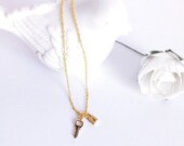 Delicate gold necklace with small gold padlock and key charms