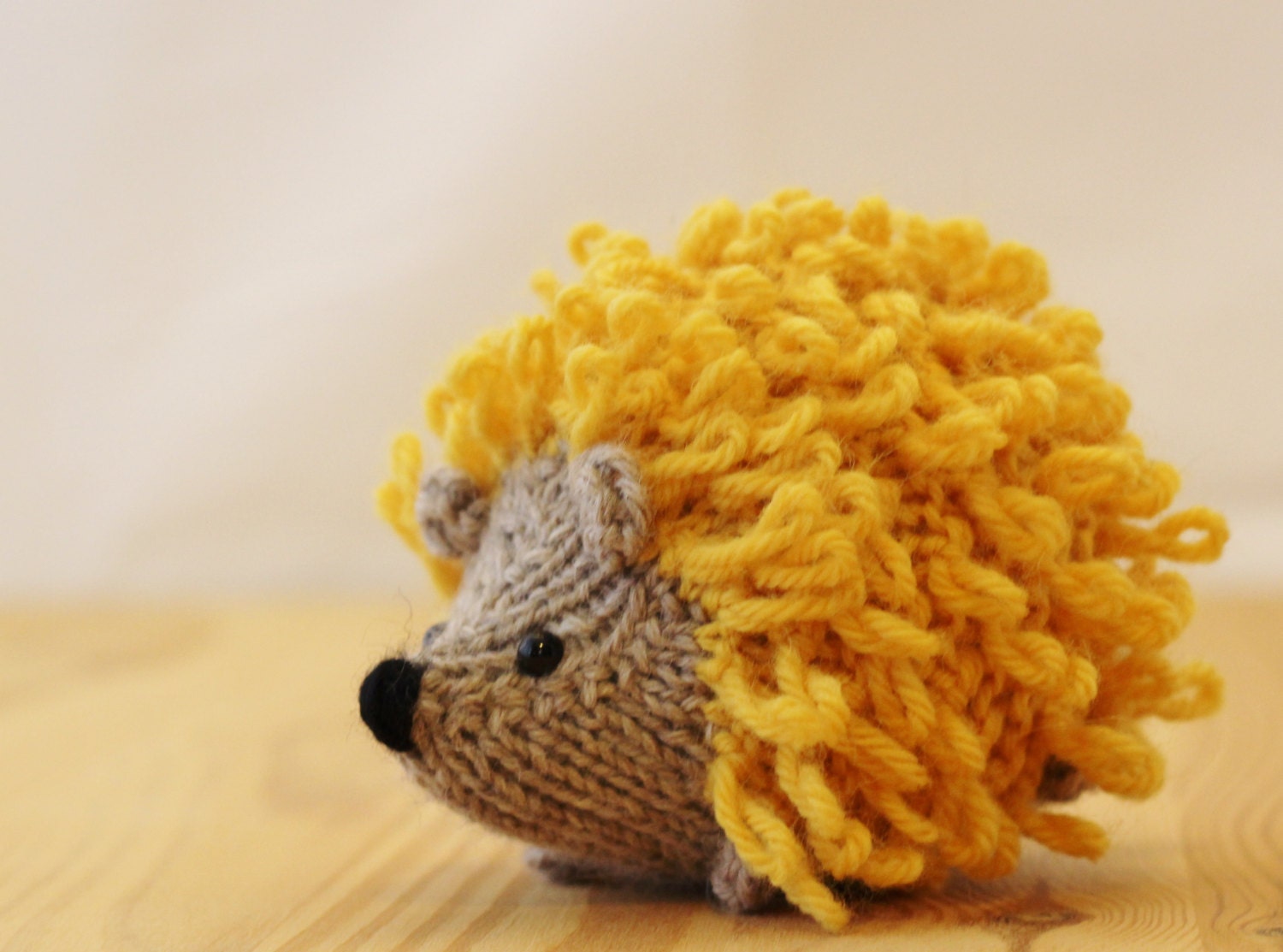Little knitted hedgehog in gray and bright yellow, stuffed wool toy