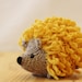 Little knitted hedgehog in gray and bright yellow, stuffed wool toy