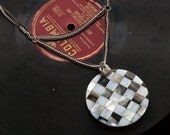 black and white checkerboard shell pendant with contrasting gunmetal and silver toned chain // short mixed metals necklace