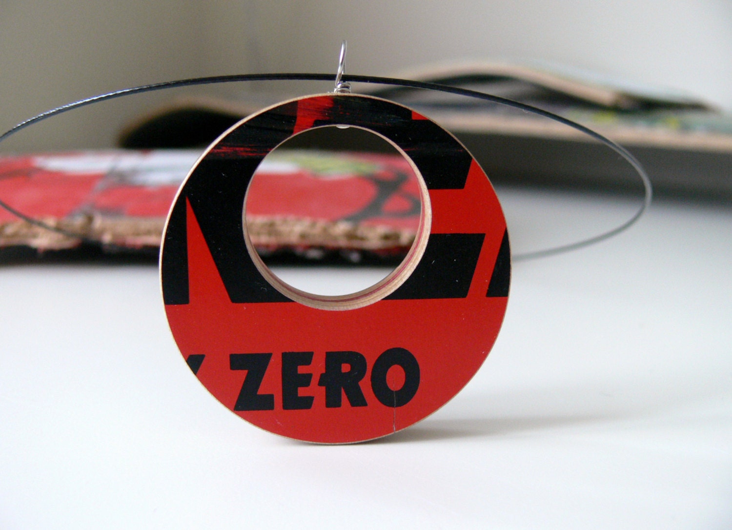 Recycled Skateboard Reversible Wood Pendant on a Black Wire Necklace with Red and Black Graphic and Purple, Red and Natural Maple Layers