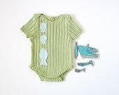 Knitted ribbed onesie in ocean green with fishes. 100% cotton.