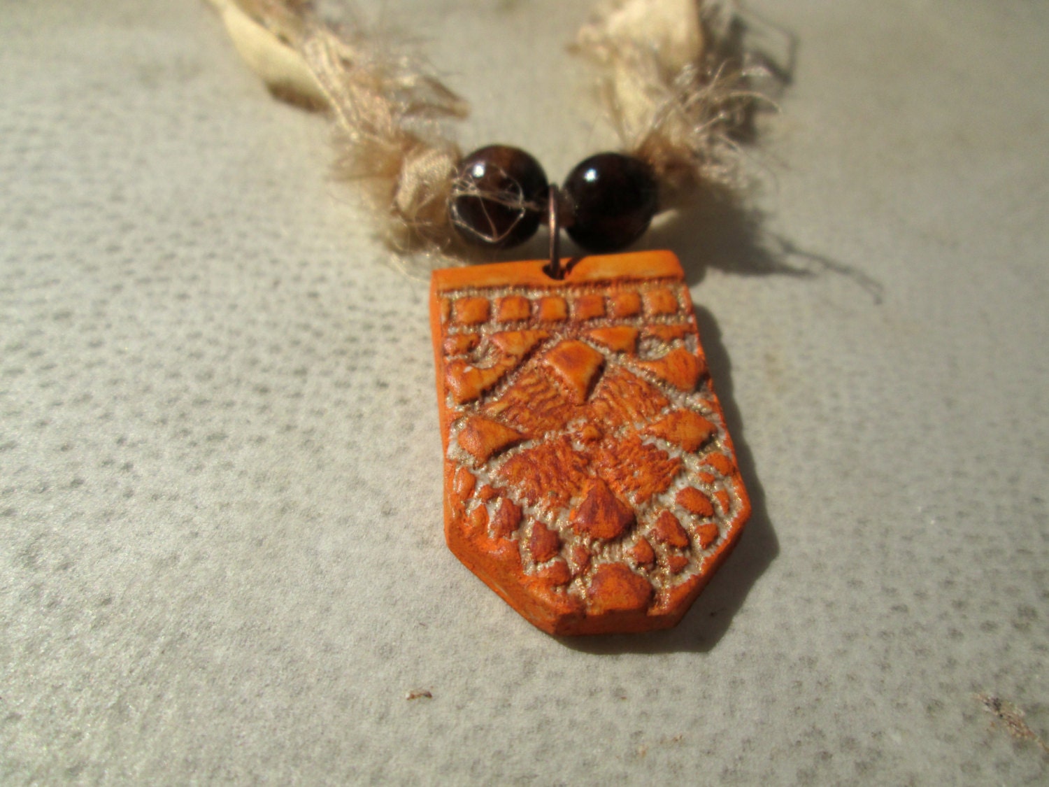 Magnolia. Lace Textured Polymer Clay Pendant on Recycled Sari Silk Ribbon. Brown Wooden Beads. Orange, Tan, Yellow.