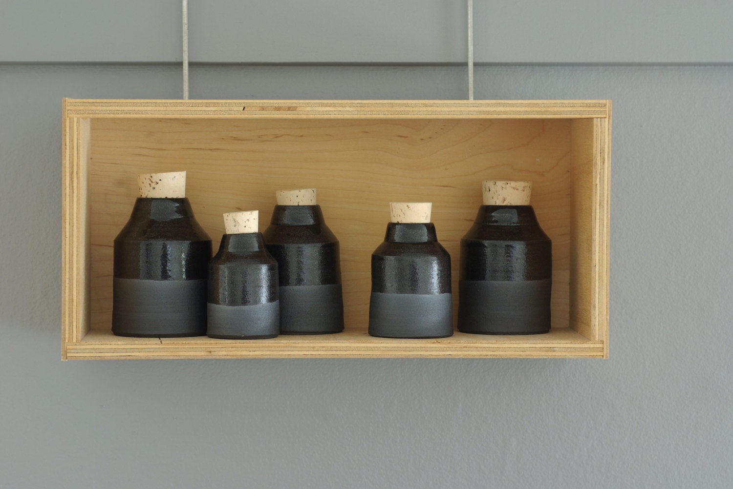 black bottle. gloss glazed black stoneware bottle with cork stopper. pottery ceramic modern minimal simple
