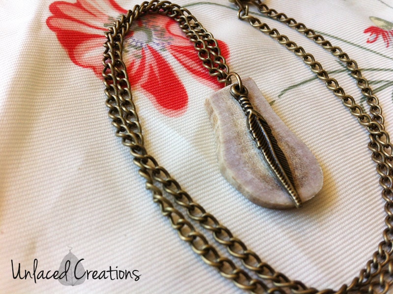 theron. a deer antler and feather brass necklace.