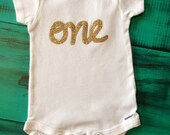 Short Sleeve first birthday onesie with gold glitter, pink glitter, pink or blue lettering - OliveandBirdie