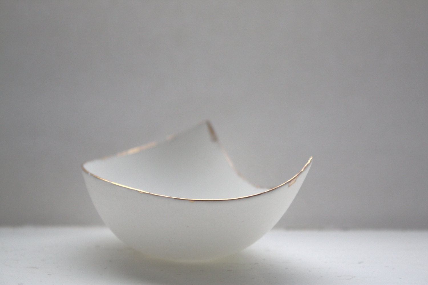 Stoneware fine bone china bowl with real gold resembles a small boat.