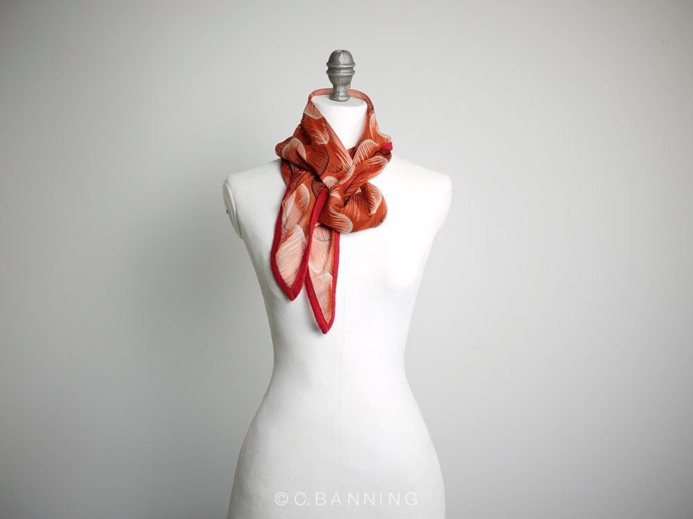 Pumpkin orange silk chiffon scarf in an abstract circle print with red trim. - byCinneWorthington
