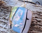 Stunning wire wrapped dichroic glass pendant with blue, pink,green and black accents