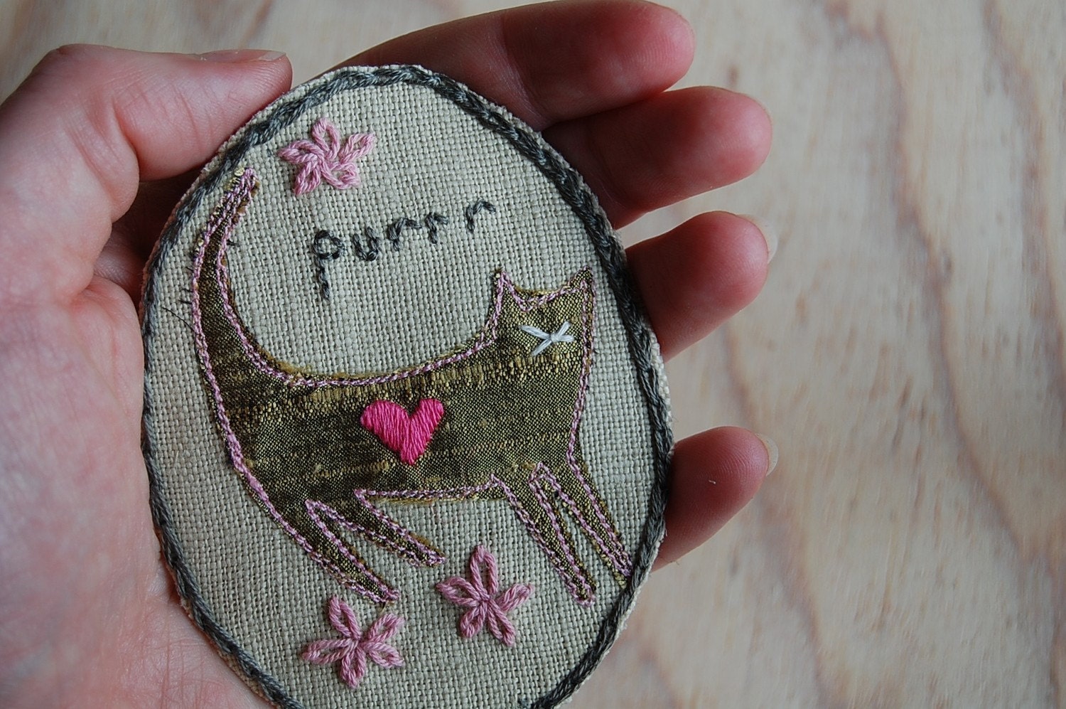 Hand embroidered oval linen cat brooch