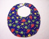 Baby bib, four soft layers, reversible, blue with red, green, and yellow dinos