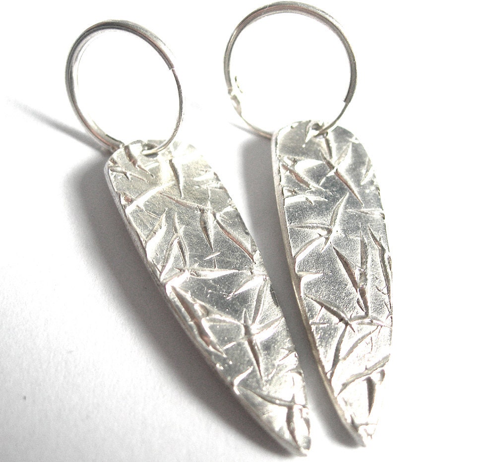 Silver hoop earrings with 'falling leaves' patterned dangle