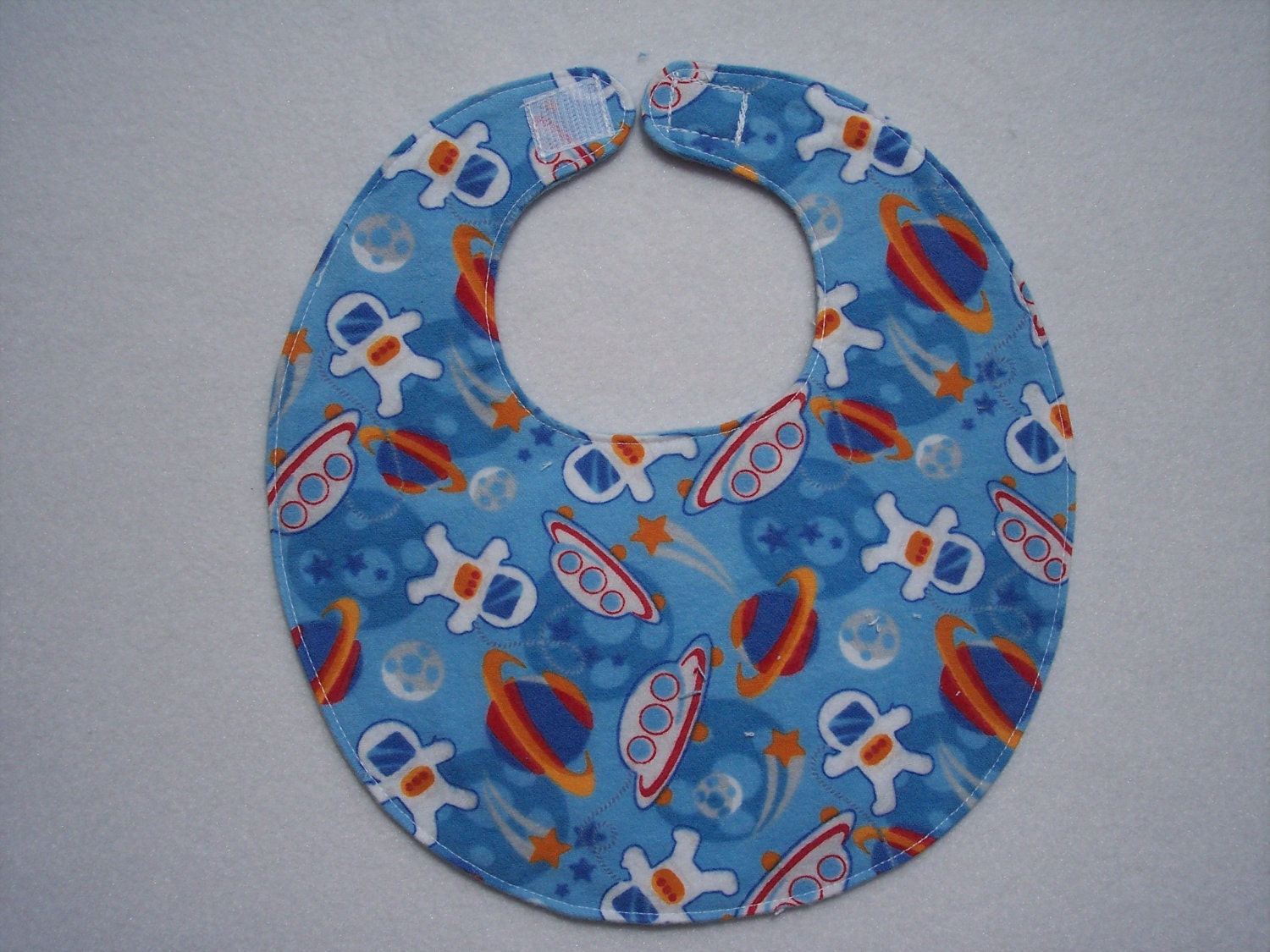 Baby bib, four soft layers, reversible, blue with space ships