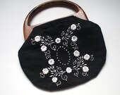 black linen clutch purse. white embroidered flowers. bermuda. wood handles.