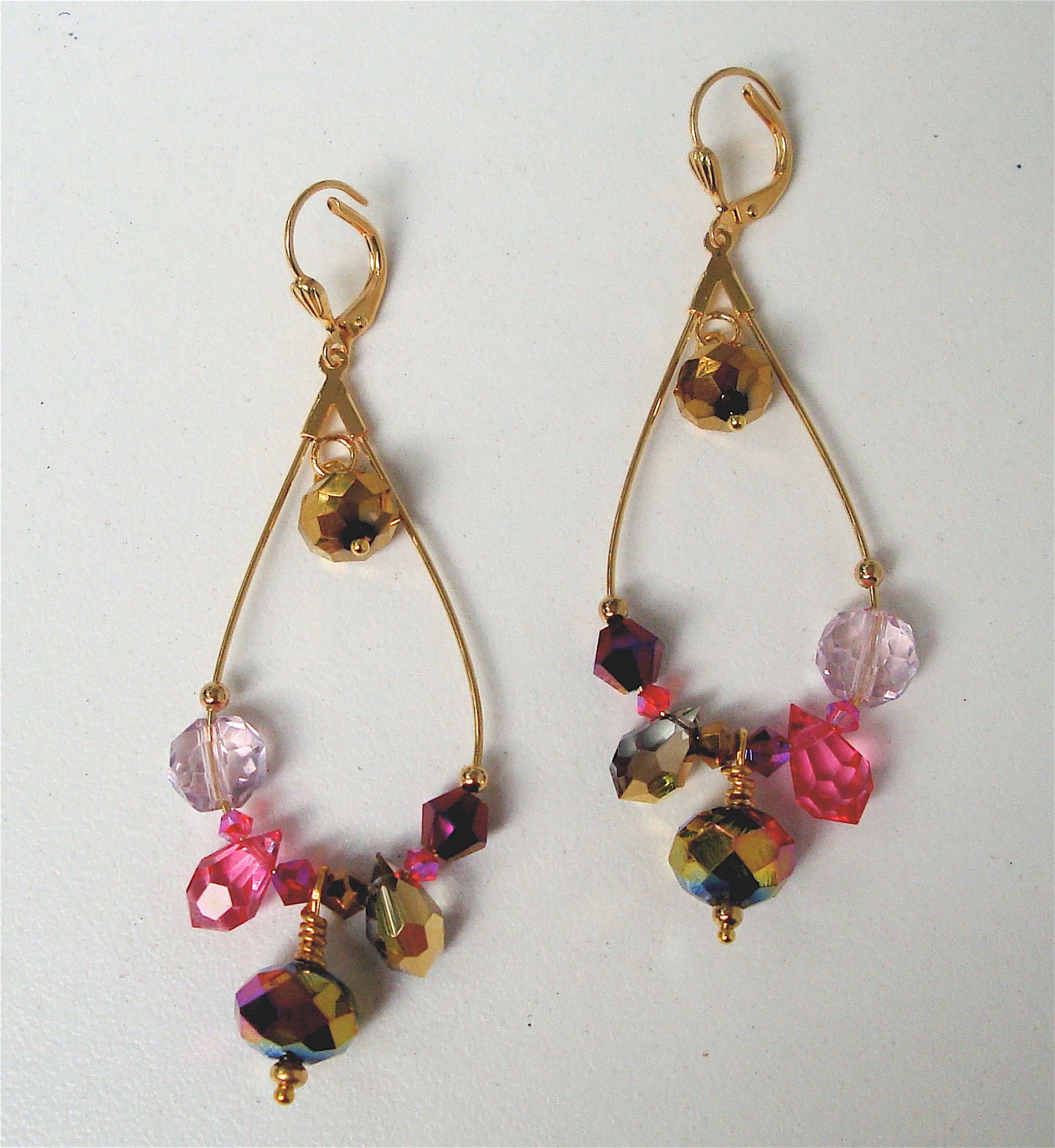 Gold tone elongated hoop earrings with pink & gold crystals and glass beads