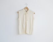 Vintage ivory knit sweater vest with a ribbon .